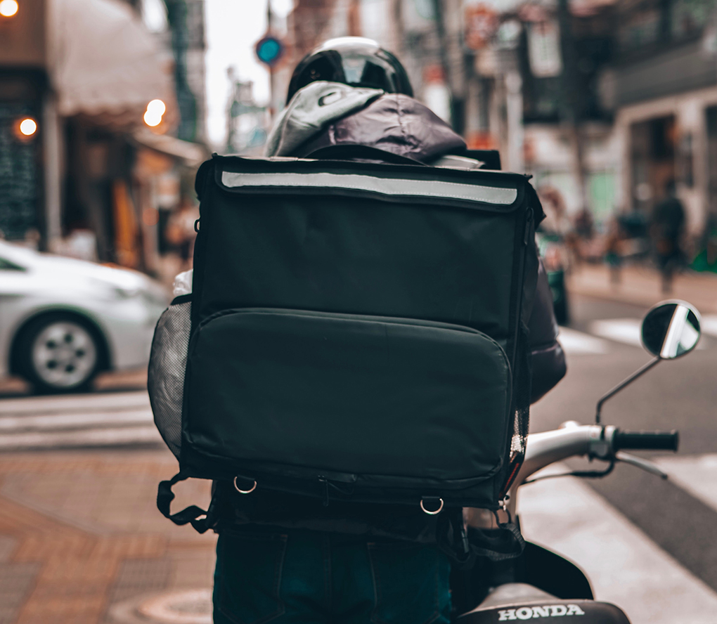 person riding a delivery cycle down a street